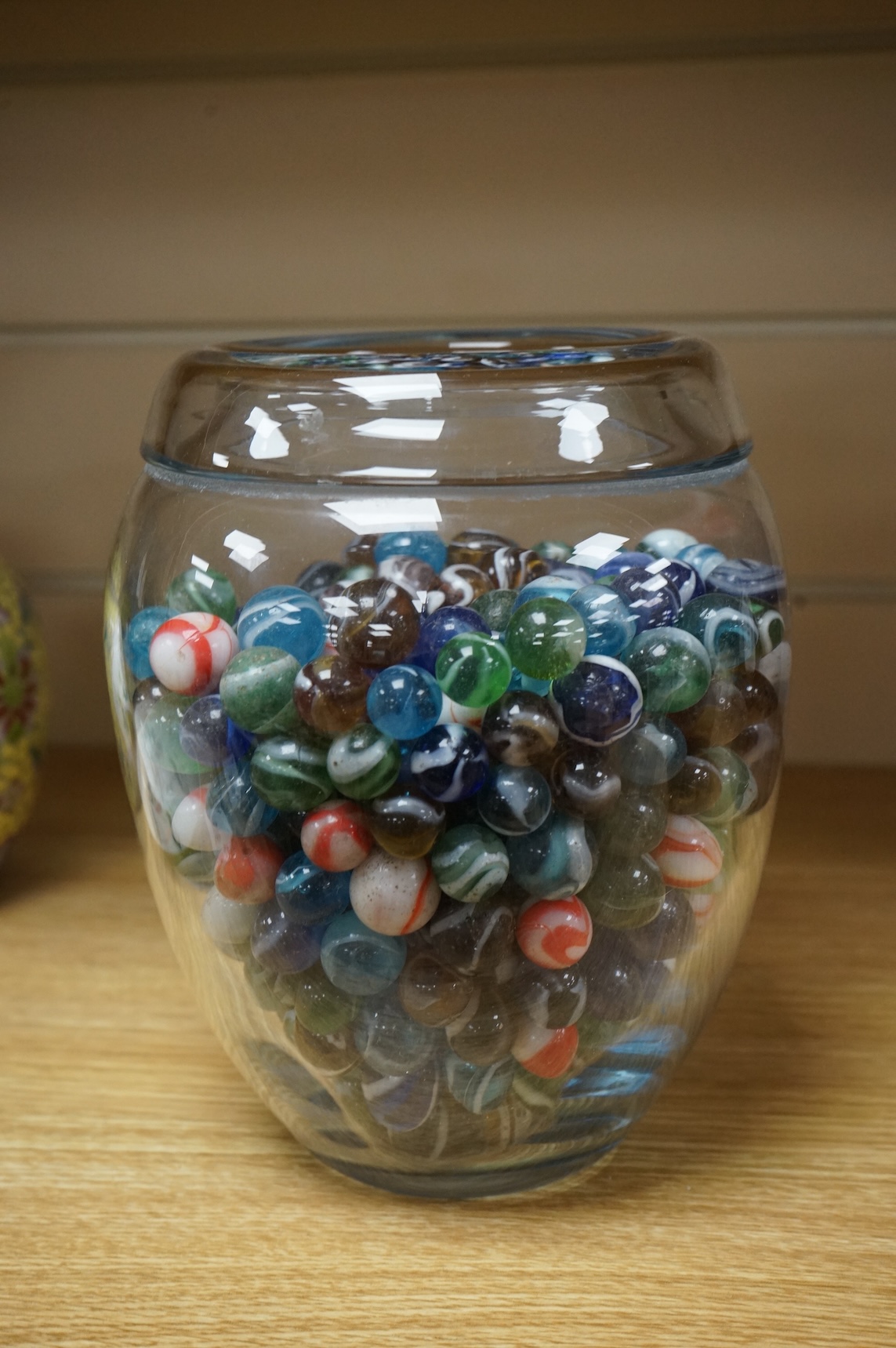 A glass vase possibly by Holmgaard, containing a large collection of late 19th/early 20th century glass marbles, 19cm high